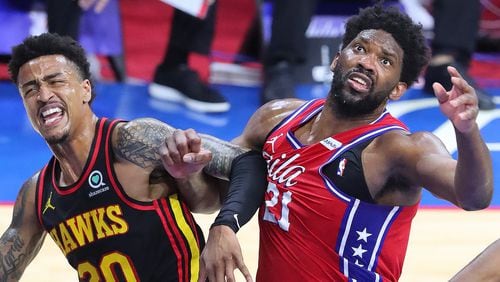 Hawks forward John Collins and Sixers center Joel Embiid battle for a rebound under the basket during Sunday's Eastern Conference semifinal matchup in Philadelphia.