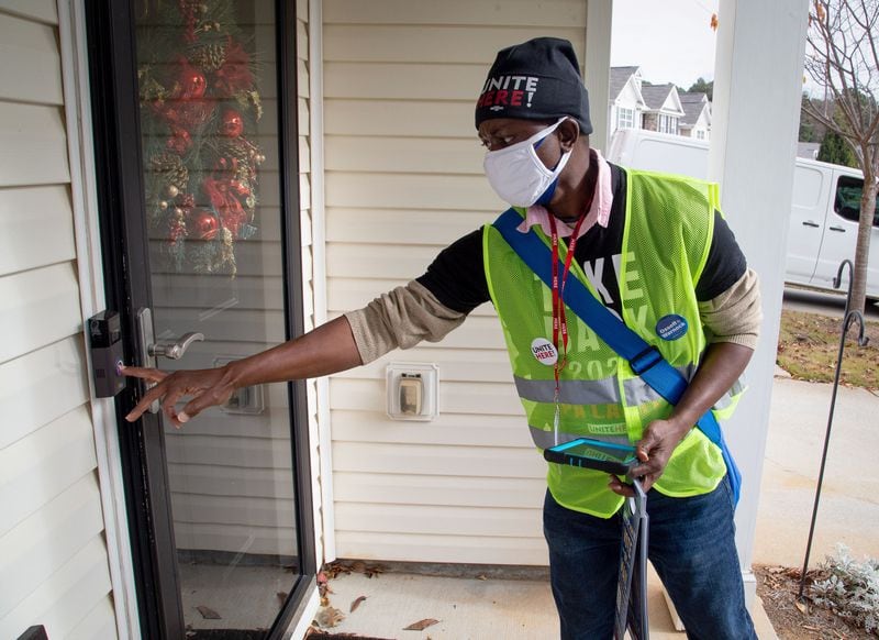 Canvasser Jenkins Kolongbo, who supports the Democrats, rings the doorbell at a house in a Scottdale neighborhood on Dec. 12, 2020. (Steve Schaefer for The Atlanta Journal-Constitution) 