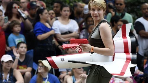 9/1/18 - Atlanta - A cosplayer dressed as Kara Thrace, the Viper pilot in the television series “Battlestar Galactica,” walks down Peachtree Street with her Viper at the annual Dragon Con Parade on Saturday, September 1. JENNA EASON/JENNA.EASON@COXINC.COM