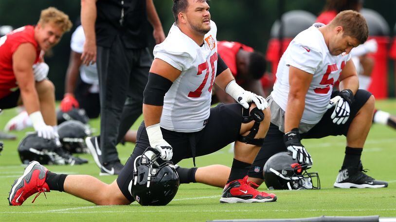 Tackle Jake Matthews (left) and center Alex Mack stretch out during minicamp. (Curtis Compton/ccompton@ajc.com)