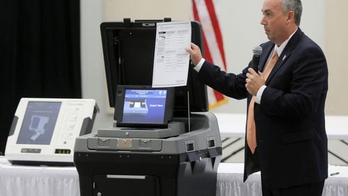 Mac Beeson from Election Systems & Software demonstrates the scanner portion of his company’s voting system during a meeting Thursday of the state’s Secure, Accessible & Fair Elections Commission, which is which is evaluating whether to switch from electronic voting machines to ones that offer paper ballots for verification and auditing. Voting machine companies demonstrated their products at the Columbia County Exhibition Center. Vendors present included Clear Ballot, Unisyn Voting Solutions, Smartmatic, Election Systems & Software, Hart InterCivic and Dominion Voting. BOB ANDRES /BANDRES@AJC.COM