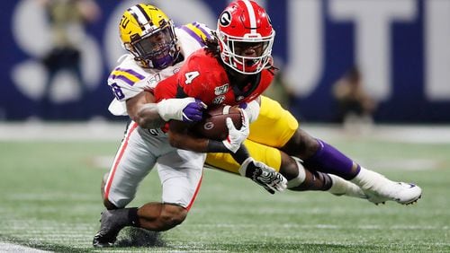 James Cook of the Georgia Bulldogs is tackled in the second half against the LSU Tigers during the SEC Championship game at Mercedes-Benz Stadium on Dec. 7, 2019. (Photo by Todd Kirkland/Getty Images)