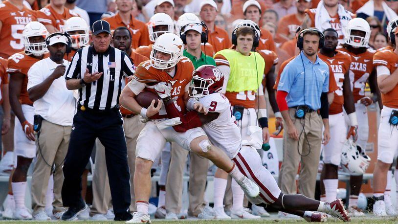 Texas quarterback Sam Ehlinger is tackled by Oklahoma linebacker Kenneth Murray during their game in 2017.
