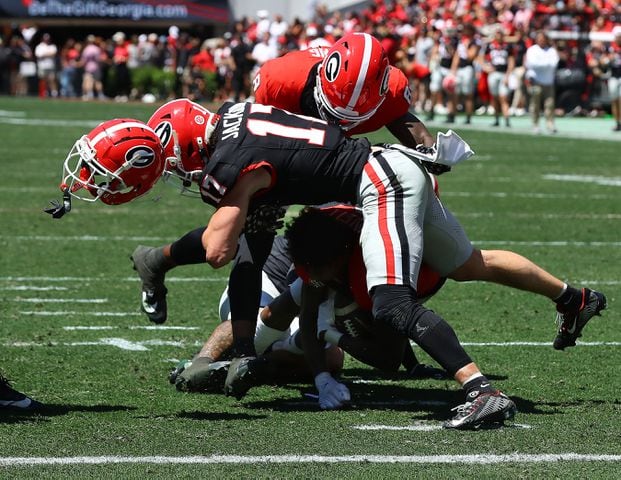 Georgia defensive back Dan Jackson levels wide receiver Dominic Lovett, separating him from his helmet, during the G-Day game on Saturday, April 13, 2024 in Athens.  Curtis Compton for the Atlanta Journal Constitution