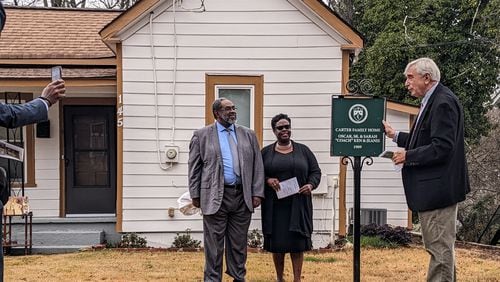 Members of the Carter family, Marcus Carter and Rev. Kennetta Carter, stand beside Marietta Mayor Steve "Thunder" Tumlin with the historic home marker for the 1909 Carter House in Marietta, Georgia, on December 7, 2022. (Photo by Cobb Landmarks)