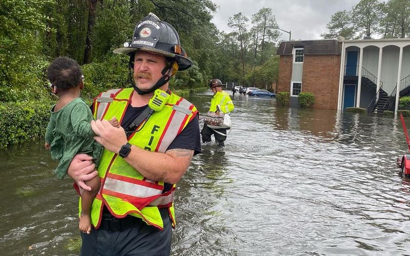 A Valdosta firefighter rescues a small child in a flooded area after Hurricane Idalia hit parts of Georgia last week. (Valdosta Fire Department)