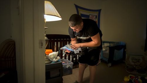 Kenneth Caban Gonzalez puts away clean laundry for his son Noah. The Hinesville resident does not have a Georgia drivers license and has had a tough time finding a job. He does all he can around the house in support of his family while he’s unemployed. (AJC Photo/Stephen B. Morton)