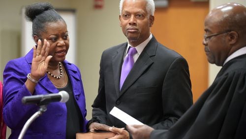Mereda Davis Johnson stands with her husband, U.S. Rep. Hank Johnson, in 2015 as she is sworn in as a DeKalb County commissioner by Superior Court Judge Gregory A. Adams. The congressman has donated $3,000 in money he collected for his campaign to his wife’s campaign committee. From 2008 to February 2015, he also paid her more than $50,000 for consulting work. “Quite frankly, my wife is quite effective at helping me,” he said. “I can probably get her to do things for less money than it would cost for someone else who would not do as well a job as she.” KENT D. JOHNSON /KDJOHNSON@AJC.COM