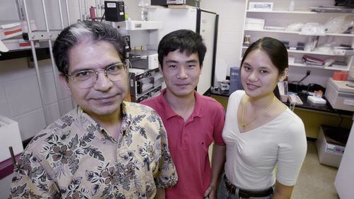 Harish Joshi, left, Associate Professor of Cell Biology at Emory Univserity, with two doctoral students, Jun Zhou center, and Joyce Yao, in the cell biology labs at Emory Wednesday on Aug. 23, 2000. (Kimberly Smith/staff)
