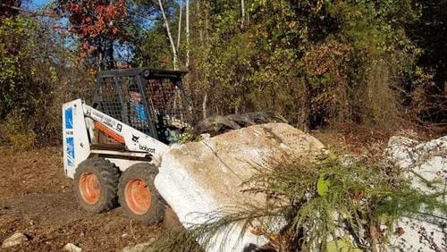 Scott Webber drives a machine that hauled debris from Lake Lanier during a cleanup effort. (Credit: Gainesville Times)