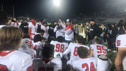 Milton coach Ben Reaves talks and celebrates with his team after a 45-35 win over Grayson in the Class 7A semifinals on Dec. 2, 2023, at Grayson Community Stadium.