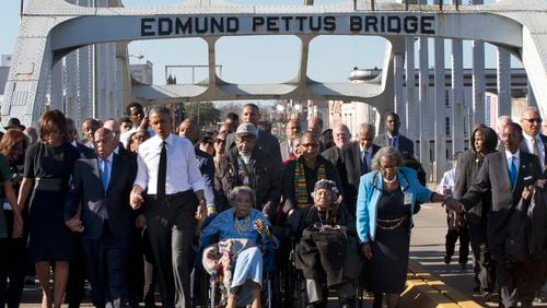 FILE - In this March 7, 2015, file photo, singing "We Shall Overcome," President Barack Obama, third from left, walks holding hands with Amelia Boynton, who was beaten during "Bloody Sunday," as they and the first family and others including Rep. John Lewis, D-Ga, left of Obama, walk across the Edmund Pettus Bridge in Selma, Ala., for the 50th anniversary of "Bloody Sunday," a landmark event of the civil rights movement. Some residents in the landmark civil rights city of Selma, Ala., are among the critics of a bid to rename the historic bridge where voting rights marchers were beaten in 1965. (AP Photo/Jacquelyn Martin, File)