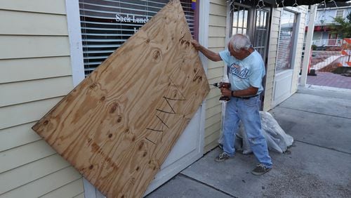 Local resident and business owner Jimmy Mock returns to his St. Marys general store on Thursday, Sept. 5, 2019, taking the boards down to begin moving merchandise back in and reopening the business after Hurricane Dorian. Mock’s business appeared to have escaped with minor wind damage. CURTIS COMPTON / CCOMPTON@AJC.COM
