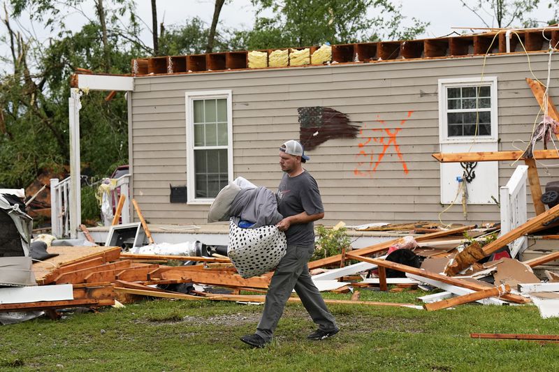 Stephen Morgan removes belongings from his storm damaged home along Blackburn Lane, Thursday, May 9, 2024, in Columbia, Tenn. Severe storms tore through the central and southeast U.S., Wednesday, spawning damaging tornadoes, producing massive hail, and killing two people in Tennessee. (AP Photo/George Walker IV)