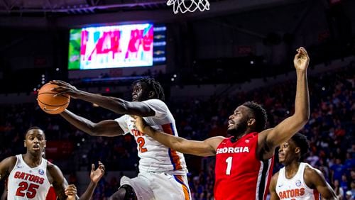 Florida forward Isaiah Stokes (2) grabs a rebound next to Georgia's Yante Maten during the first half of an NCAA college basketball game Wednesday, Feb. 14, 2018, in Gainesville, Fla.