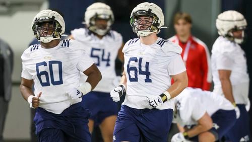 Georgia Tech offensive linemen Gabe Fortson (60) and Ryan Purves (64) participate in a drill during their first day of spring football practice at the Brock Indoor Practice Facility, Monday, March 11, 2024, in Atlanta. (Jason Getz / jason.getz@ajc.com)