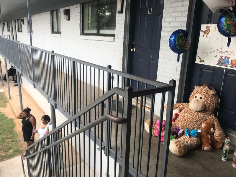 Stuffed animals, balloons and candles in front of the apartment of Lamora Williams and her children.
