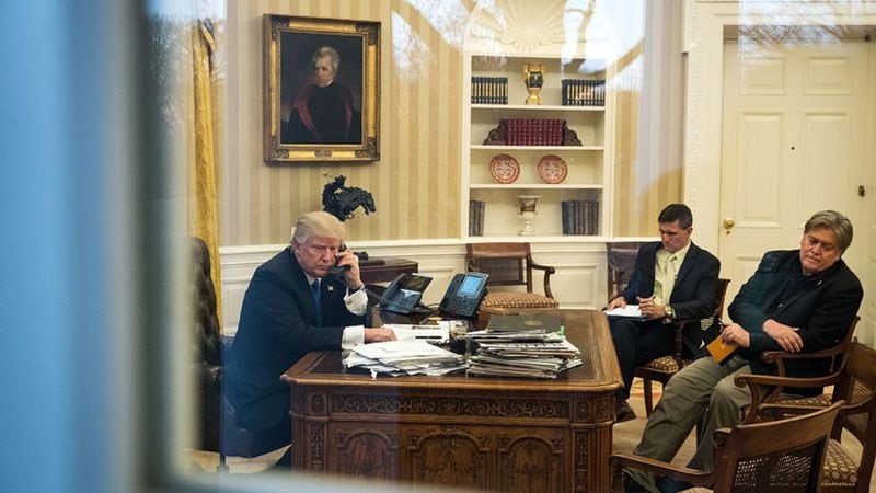 President Donald Trump speaks on the phone with Australian Prime Minister Malcolm Turnbull in the Oval Office of the White House on January 28, 2017 in Washington, DC. Also pictured, former National Security Advisor Michael Flynn, center, and former White House Chief Strategist Steve Bannon. 