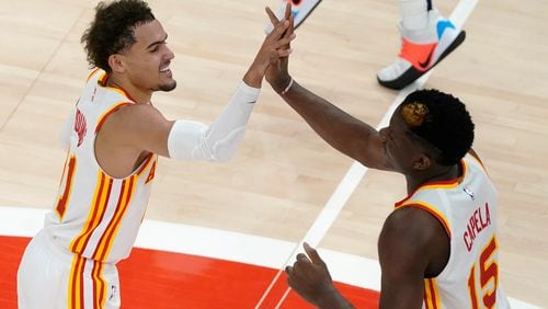 Hawks guard Trae Young (left) and center Clint Capela celebrate during a win earlier in the season. (AP Photo/John Bazemore)