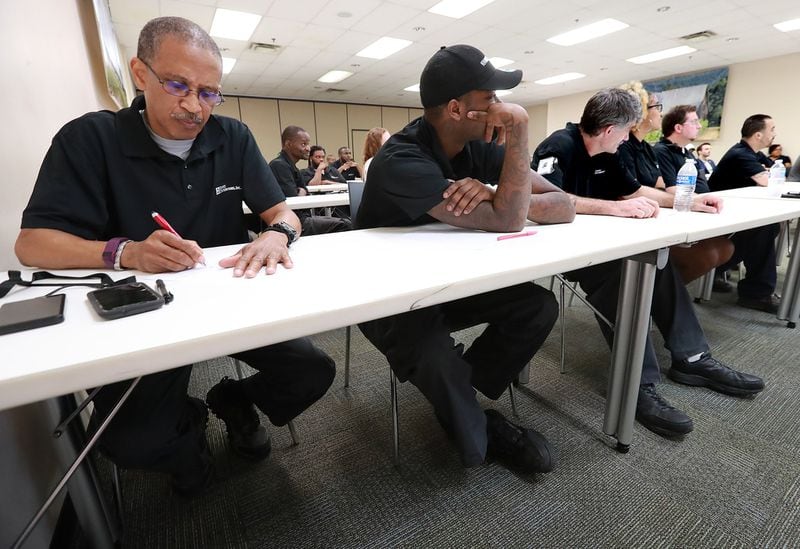 Empire Distributors employee Gerald Johnson (left) takes notes during a personal financial wellness event at the company in Atlanta. Curtis Compton/ccompton@ajc.com