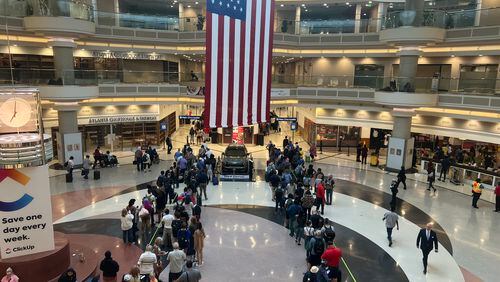 The security lines at Hartsfield-Jackson International Airport backed into the atrium early Friday, July 1, 2022.  The Atlanta airport is expected to handle 1.7 million passengers over a six-day Independence Day travel period. (Kelly Yamanouchi / Kelly.Yamanouchi@ajc.com)