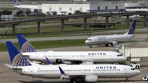 In this July 8, 2015, file photo, a United Airlines plane, front, is pushed back from a gate at George Bush Intercontinental Airport in Houston. (AP Photo/David J. Phillip, File)