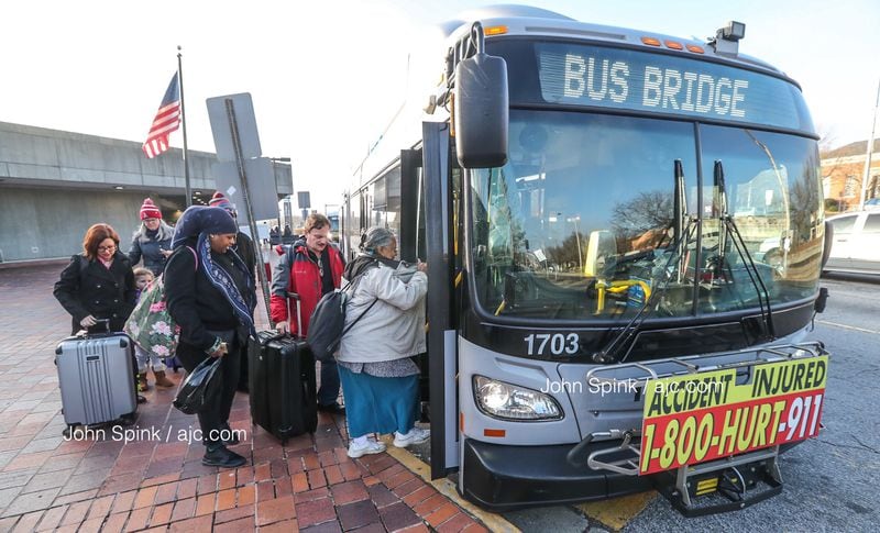 MARTA riders board a shuttle bus at the College Park station en route to the airport Wednesday morning. (Photo: JOHN SPINK / JSPINK@AJC.COM)