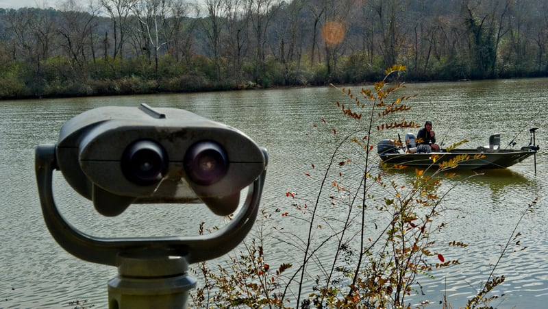 A pair of binoculars rise from the River Boardwalk Trail at the Chattahoochee Nature Center as Paul Jusiewicz fishes from his boat along the river in Roswell on Saturday, December 27, 2014. JONATHAN PHILLIPS / SPECIAL