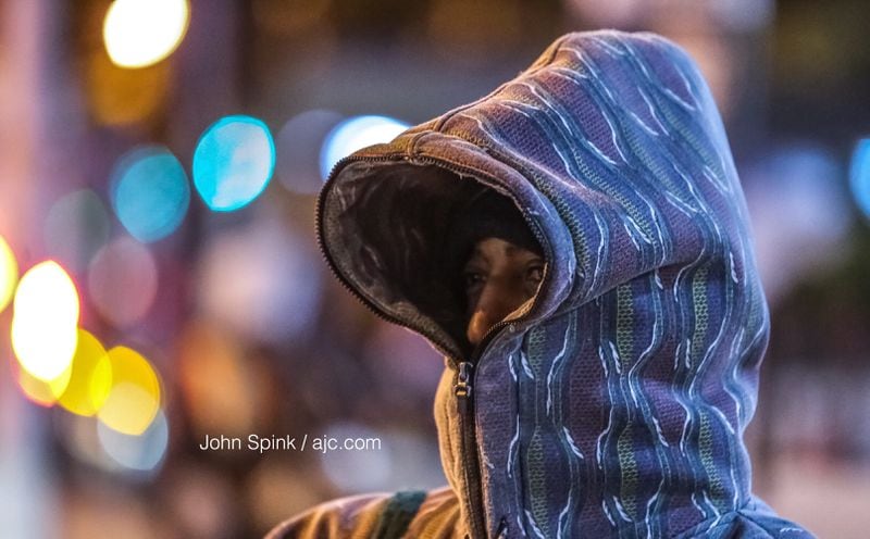 Robert Woods bundles up against the near-freezing cold and wind outside the Five Points MARTA station Tuesday morning. JOHN SPINK / JSPINK@AJC.COM