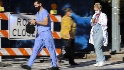 In this recent photo, medical workers move between buildings at Grady Memorial Hospital in downtown Atlanta as the COVID-19 cases in Georgia continue. (John Spink / John.Spink@ajc.com)