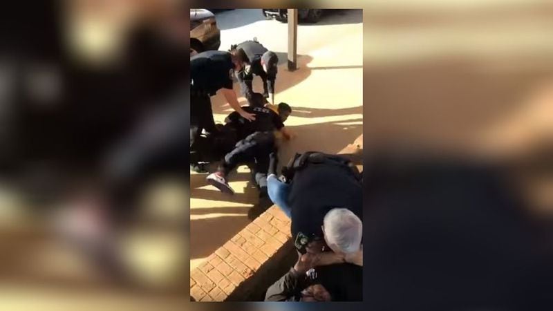 Cellphone video shows both Griffin High School students being handcuffed following an incident with police earlier this month at the school's bus ramp. 