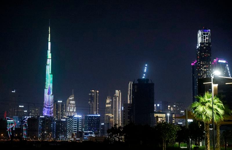 A picture shows a general view of the Dubai skyline at night, including the Burj Khalifa (left), the world's tallest building, on Dec. 1, 2023. (Ludovic Marin/AFP via Getty Images/TNS)