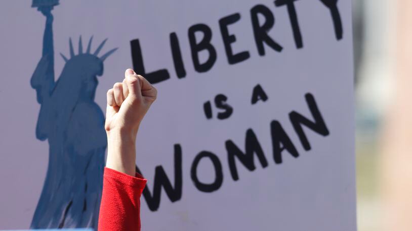 An unidentified participant raises her hand in support of a speaker during a march around the State Capitol to mark International Women's Day on Wednesday, March 8, 2017, in Denver. More than 1,000 women--and men--took part in the Denver march, one of many staged across the country by organizers of January's Women's March. The action called on women to stay home from work and not spend money in stories or online to show their economic clout on America's fabric. (AP Photo/David Zalubowski)