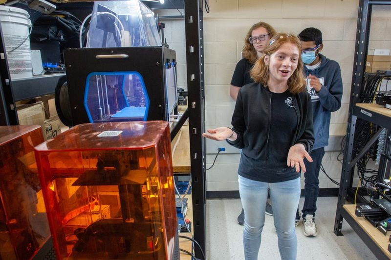 Senior Sarah Andrews talks about the 3D printer she used to make the helmet camera mount she designed for a team of police officers in Duluth, Lilburn and Suwanee at Maxwell High School of Technology Thursday, March 17, 2022. (Steve Schaefer for The Atlanta Journal-Constitution)