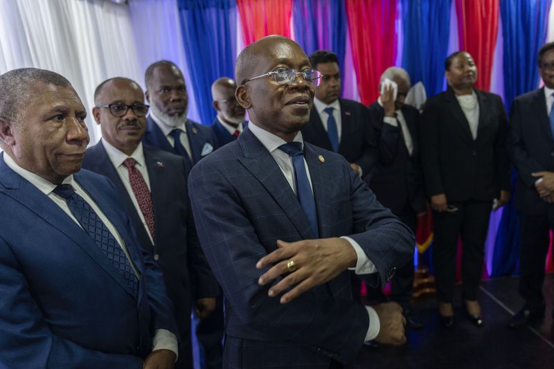 Interim Prime Minister Michel Patrick Boisvert, center, is flanked by transitional council members during an installation ceremony, in Port-au-Prince, Haiti, April 25, 2024. (AP Photo/Ramon Espinosa)