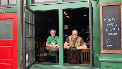 Manager John Gore, left, and co-owner Phil Roness at Meehan’s Public House in Vinings. The Meehan’s intown was closed after Mayor Keisha Lance Bottoms ordered all restaurants and bars closed Thursday to help limit the spread of COVID-19. Roness said he is managing the Meehan’s in Vinings as a “stationary food truck,” offering a limited menu to go and trying to keep some staff paid.