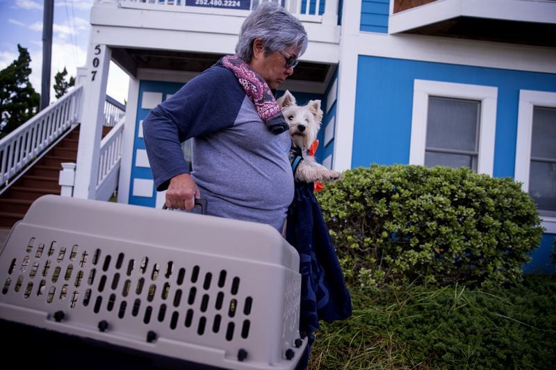 A person prepares to evacuate with her dog in the Outer Banks area of North Carolina, on Tuesday, Sept. 11, 2018, ahead of Hurricane Florence. 