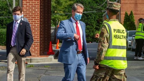 Gov. Brian Kemp talks with a member of the Georgia National Guard after touring a COVID-19 testing site in Gwinnett County. The General Assembly voted in March to give Kemp emergency powers to help the state function during the COVID-19 pandemic. Legislation now under consideration in the Georgia House would give the Legislature more control over those powers in the future. STEVE SCHAEFER FOR THE ATLANTA JOURNAL-CONSTITUTION