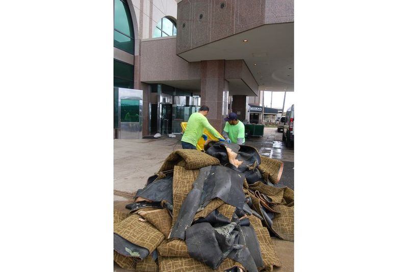 This photo from the Jacksonville Daily Record shows workers pulling soaked carpets out of the Hyatt Regency Riverfront in Jacksonville, Fla. The hotel, the biggest in Jacksonville, remains closed during the weekend of the Georgia-Florida game, due to flooding from Hurricane Irma. JACKSONVILLE DAILY RECORD