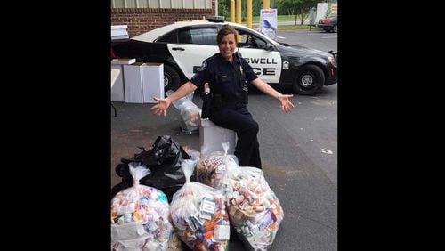 Roswell Police Officer Lisa Holland shown with the 241 pounds of drugs taken by the department on "Drug Take-Back Day."