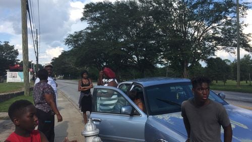 Family and friends of 18-year-old Markeith Oliver await information as they gather on Martin Luther King Jr. Drive on Friday afternoon. J.D. CAPELOUTO