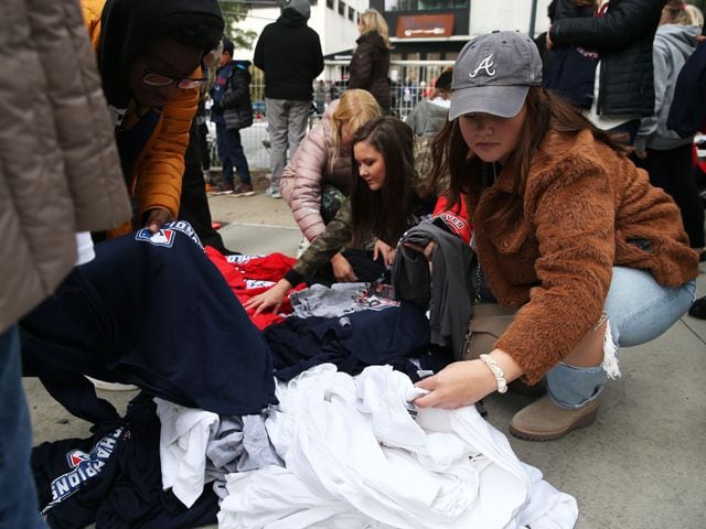 Taylor Wise, right, from Birmingham, Alabama, and Carley Batchelor, center, from Gwinnett County, look through World Series shirts for sale before the Braves' World Series parade in Atlanta, Georgia, on Friday, Nov. 5, 2021. Batchelor, a teacher in Gwinnett, was able to see the parade with some metro Atlanta schools being closed. (Photo/Austin Steele for the Atlanta Journal Constitution)