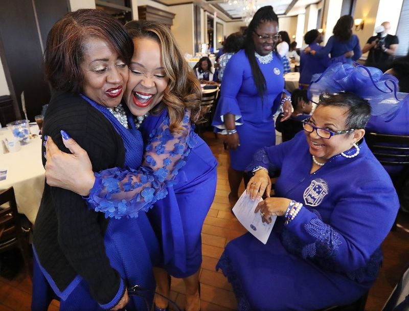 Zeta Phi Beta Sorority members Tara Lockett (from left) and Michelle Langham-Robinson share a hug with Lois McKellar looking on as they arrive for the 100 Years of Finer A Centennial Celebration on Thursday, January 16, 2020, in Dunwoody. (Curtis Compton / ccompton@ajc.com)