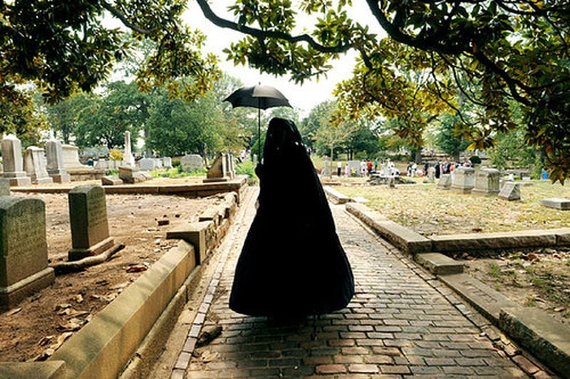 Dressed as a Civil War widow in the first stage of mourning, Carolyn Balog of Hampton, Ga., walks among the graves at Oakland Cemetery during Sunday in the Park. Among the performers was Doug Lothes doing 'Gone With the Wind in Twenty Minutes.'