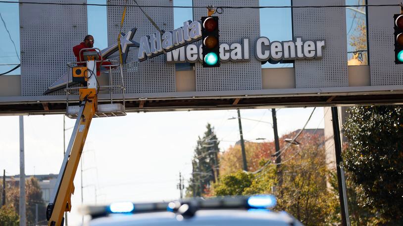 Crew members work removing the signs out of the bridge from the Atlanta Medical Center on Tuesday, November 1, 2022. The doors to Atlanta Medical Center downtown will be locked at midnight. Miguel Martinez / miguel.martinezjimenez@ajc.com