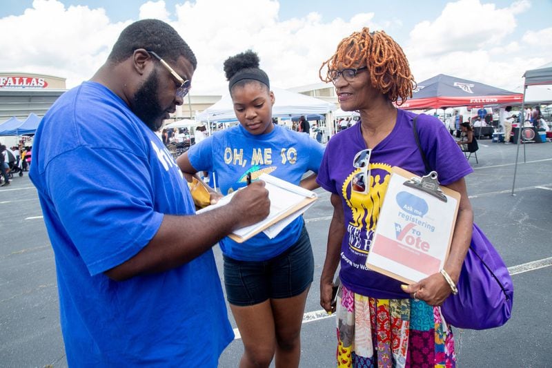 Andrea Lanes (right) helps Daniel Harris register to vote while his daughter Dania Harris looks on during the first annual Taste of Southwest Atlanta held at Greenbriar Mall on Saturday, June 29, 2019. STEVE SCHAEFER / SPECIAL TO THE AJC