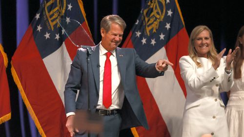 Gov. Brian Kemp acknowledges supporters after being re-elected at Coca-Cola Roxy at the Battery, Tuesday, November 8, 2022, in Atlanta. Also shown is Marty Kemp, Brian’s wife.  (Jason Getz / Jason.Getz@ajc.com)