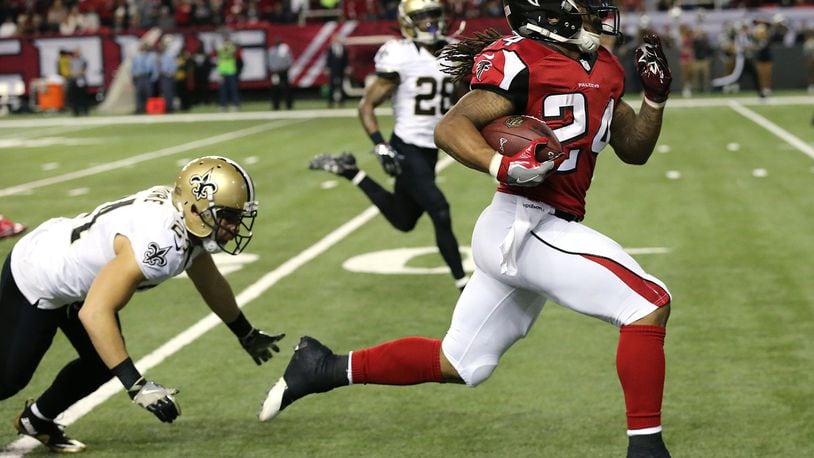 Running back Devonta Freeman breaks away from Saints defenders for a 75-yard touchdown run to put the Falcons ahead 14-3 during the first quarter in an NFL football game on Sunday, Jan. 1, 2017, at the Georgia Dome. (Curtis Compton/ccompton@ajc.com)