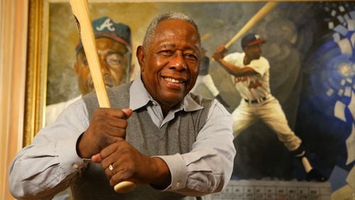 Braves legend Hank Aaron strikes a familiar pose during an interview in the living room of his home on the eve of his 80th birthday in 2014. Aaron died Jan. 22 at the age of 86. CURTIS COMPTON / CCOMPTON@AJC.COM