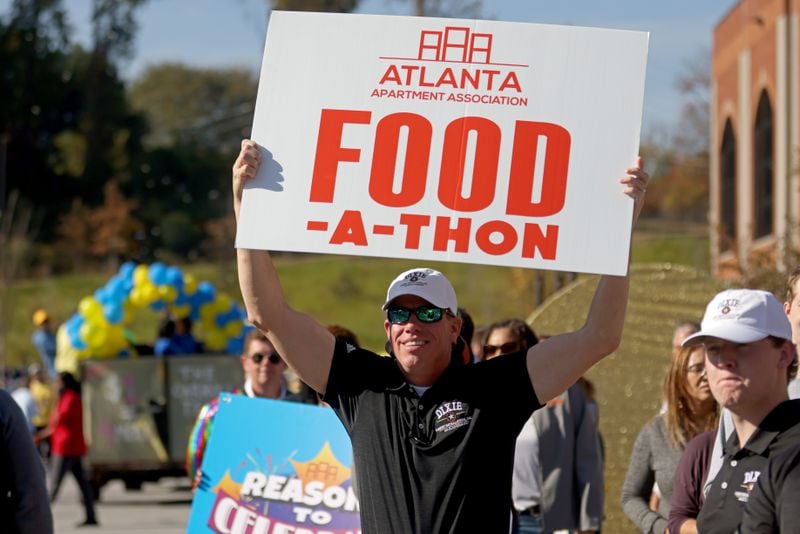 Scotty Brown, of Dixie Carpet Installations, holds up a Food-A-Thon sign during the event at the Atlanta Community Food Bank, Friday, November 4, 2022, in East Point, Ga. (Jason Getz / Jason.Getz@ajc.com)